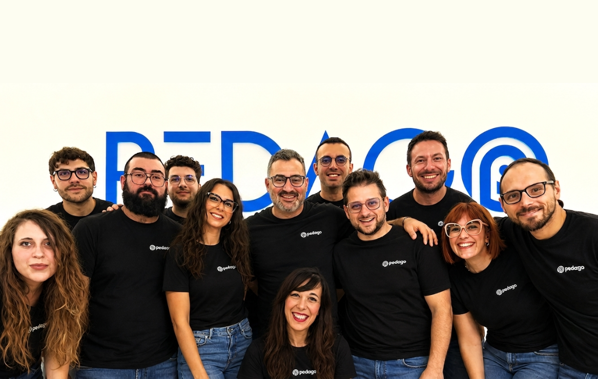 Riunione del team Pedago davanti a una lavagna con l’elenco dei corsi da produrre